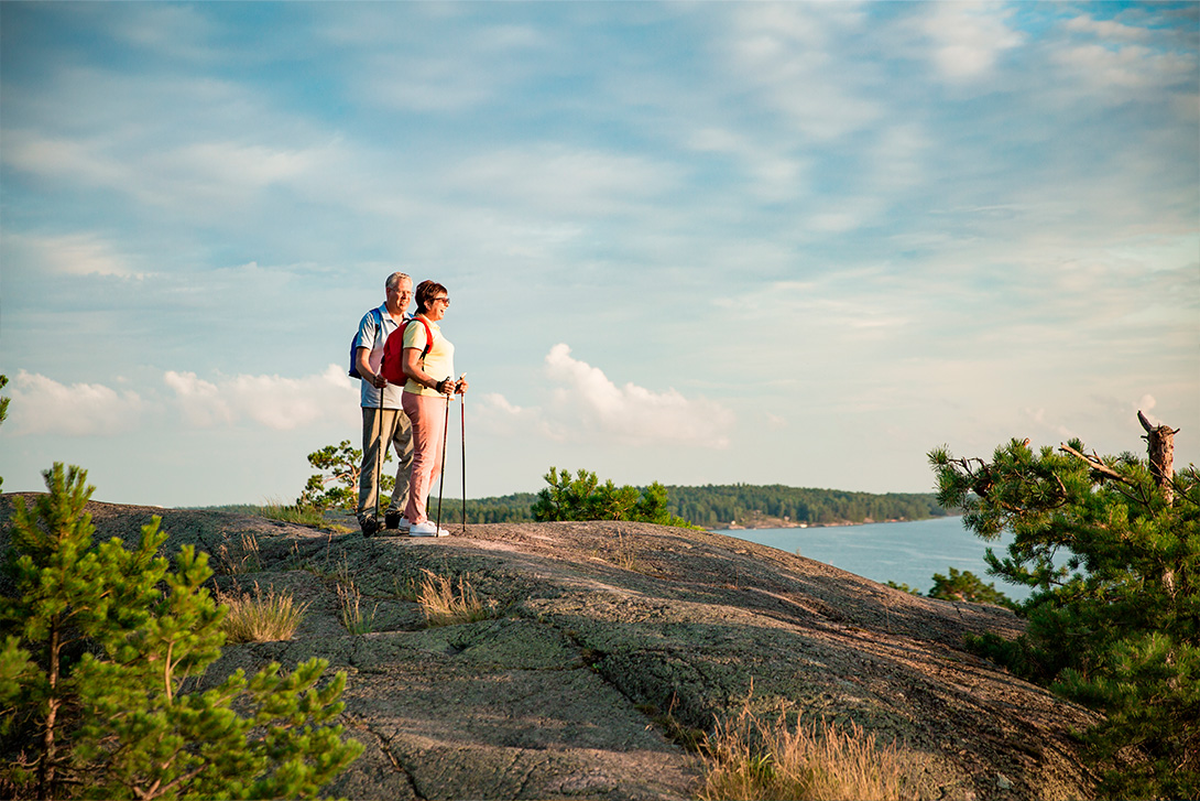 middle aged couple nordic walking in finnish archipelago