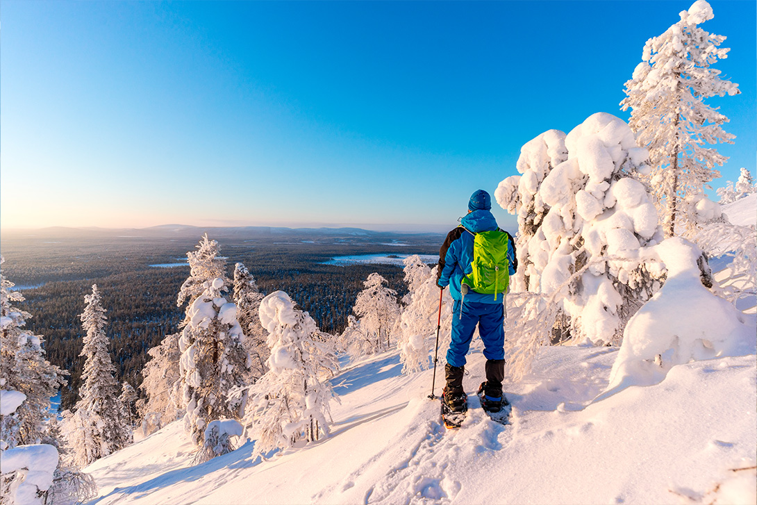 person snow shoeing in finnish lapland on top of the fell