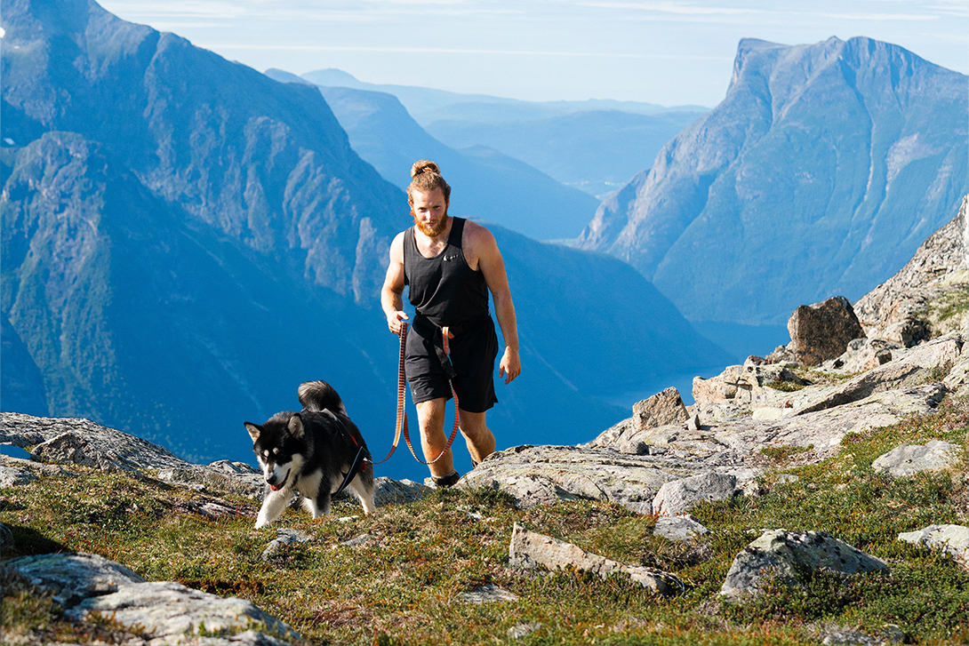 Man and dog hiking in norwegian fjords