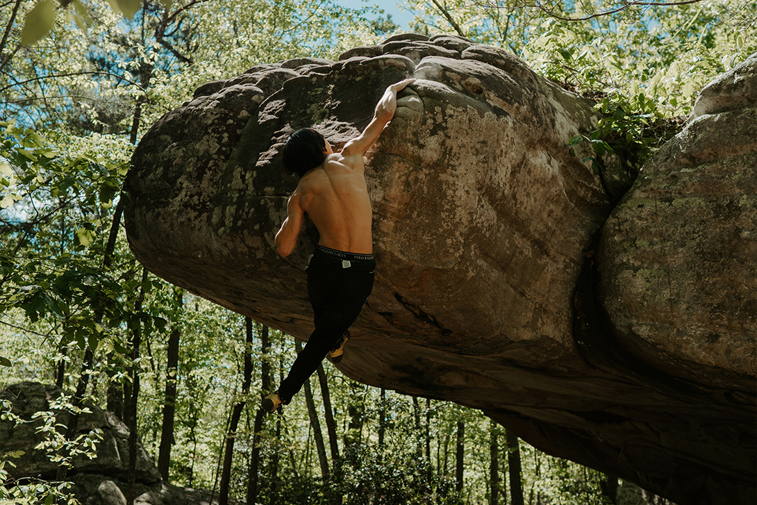 man bouldering in the woods